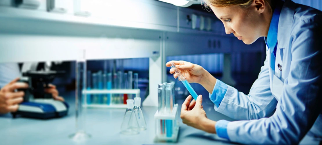 Woman working in lab with liquid dropper